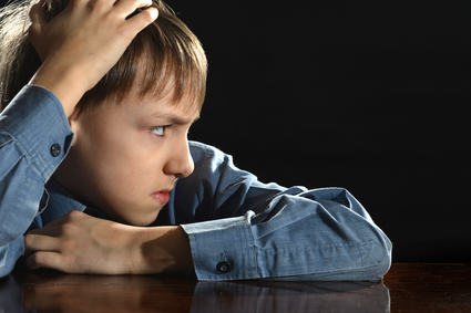 offended little boy on a black background